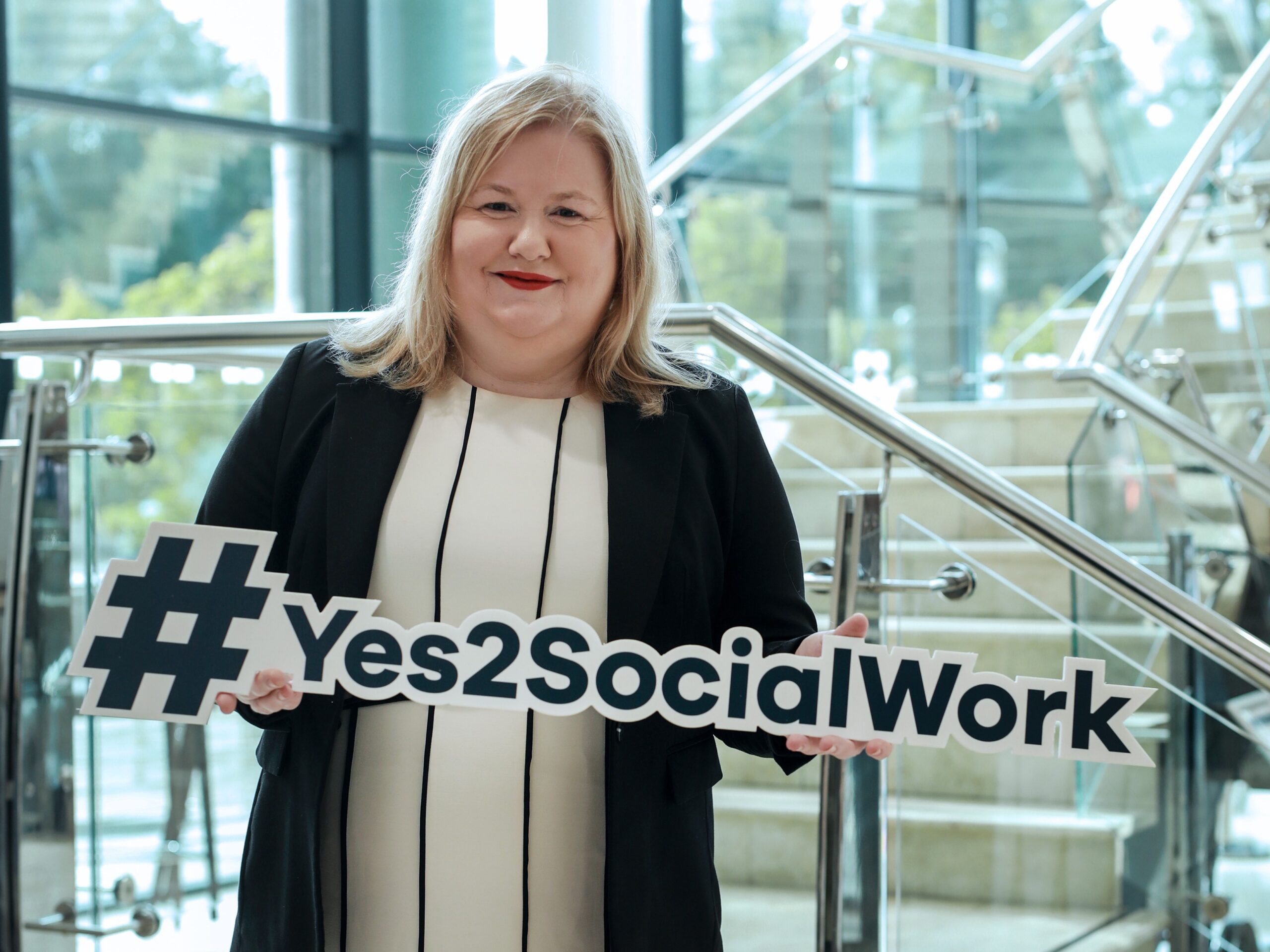 Northern Ireland Social Care Council Chief Executive Tracy Reid holding a #Yes2SocialWork hashtag prop